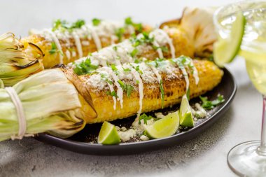 Baharat ve bir servis tabağı üzerinde taze kişniş ile süslenmiş Meksika Caddesi Mısır elote ızgara.