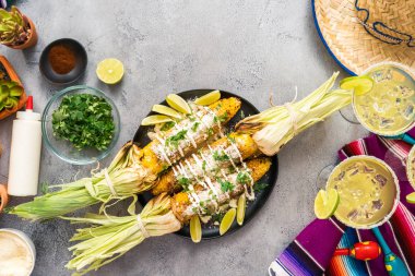 Üstten görünüm. Bir servis tabağı üzerinde baharatlar ile süslenmiş Meksika Caddesi Mısır elote ızgara.