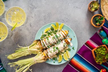 Üstten görünüm. Bir servis tabağı üzerinde baharatlar ile süslenmiş Meksika Caddesi Mısır elote ızgara.
