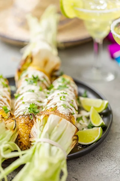 Baharat ve bir servis tabağı üzerinde taze kişniş ile süslenmiş Meksika Caddesi Mısır elote ızgara.