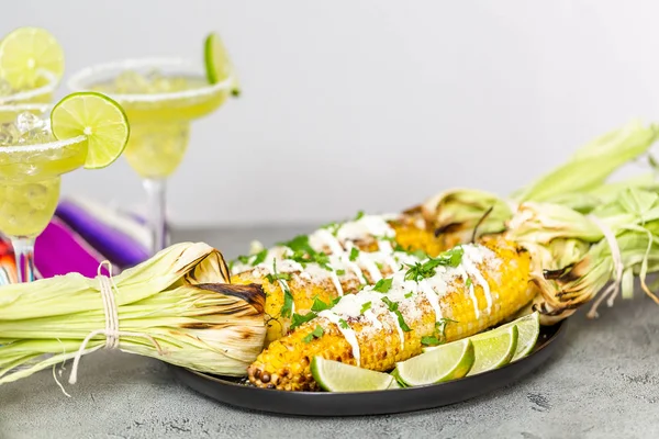 Baharat ve bir servis tabağı üzerinde taze kişniş ile süslenmiş Meksika Caddesi Mısır elote ızgara.