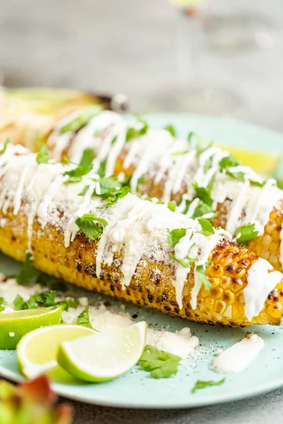 Baharat ve bir servis tabağı üzerinde taze kişniş ile süslenmiş Meksika Caddesi Mısır elote ızgara.