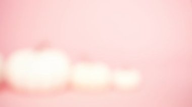 Farklı boyutlarda pembe bir arka plan üzerinde beyaz zanaat kabaklar