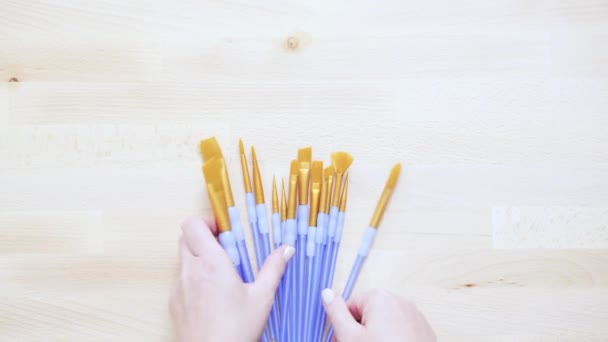 Verscheidenheid Van Nieuwe Verf Penselen Met Verf Een Houten Tafel — Stockvideo