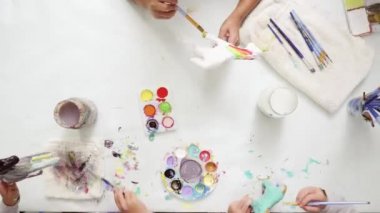 Zaman atlamalı. Adım adım. Küçük kızlar akrilik boya ile kağıt mache tek boynuzlu at boyama