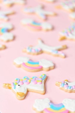 Tek boynuzlu at şekerli kurabiye pembe bir arka plan üzerine Kraliyet krema ile dekore edilmiş.