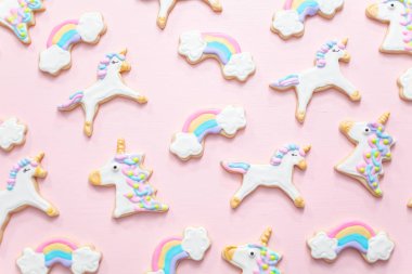 Tek boynuzlu at şekerli kurabiye pembe bir arka plan üzerine Kraliyet krema ile dekore edilmiş.