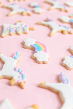 Tek boynuzlu at şekerli kurabiye pembe bir arka plan üzerine Kraliyet krema ile dekore edilmiş.