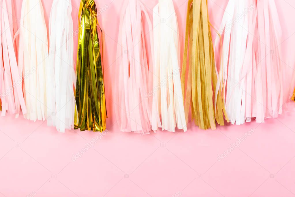 Paper tassel garland on a pink wall at the kids birthday party.