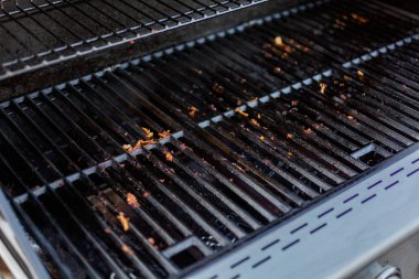 Dirty cast iron cooking grates on outdoor gas grill. clipart