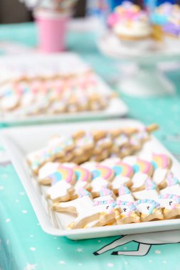 Tepsi küçük kız Doğum günü partisi hizmet üzerinde tek boynuzlu at şekerli kurabiye.