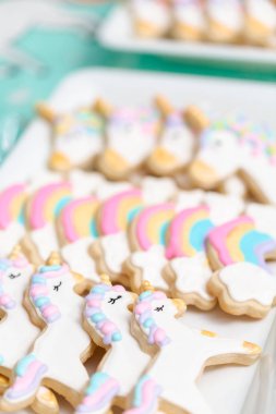 Tepsi küçük kız Doğum günü partisi hizmet üzerinde tek boynuzlu at şekerli kurabiye.