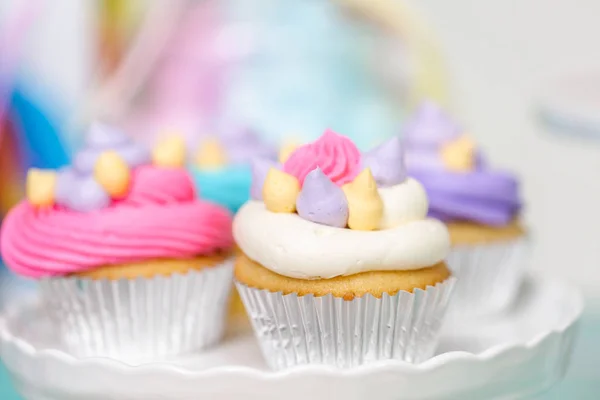 Multicolored unicorn cupcakes at little girl birthday party.