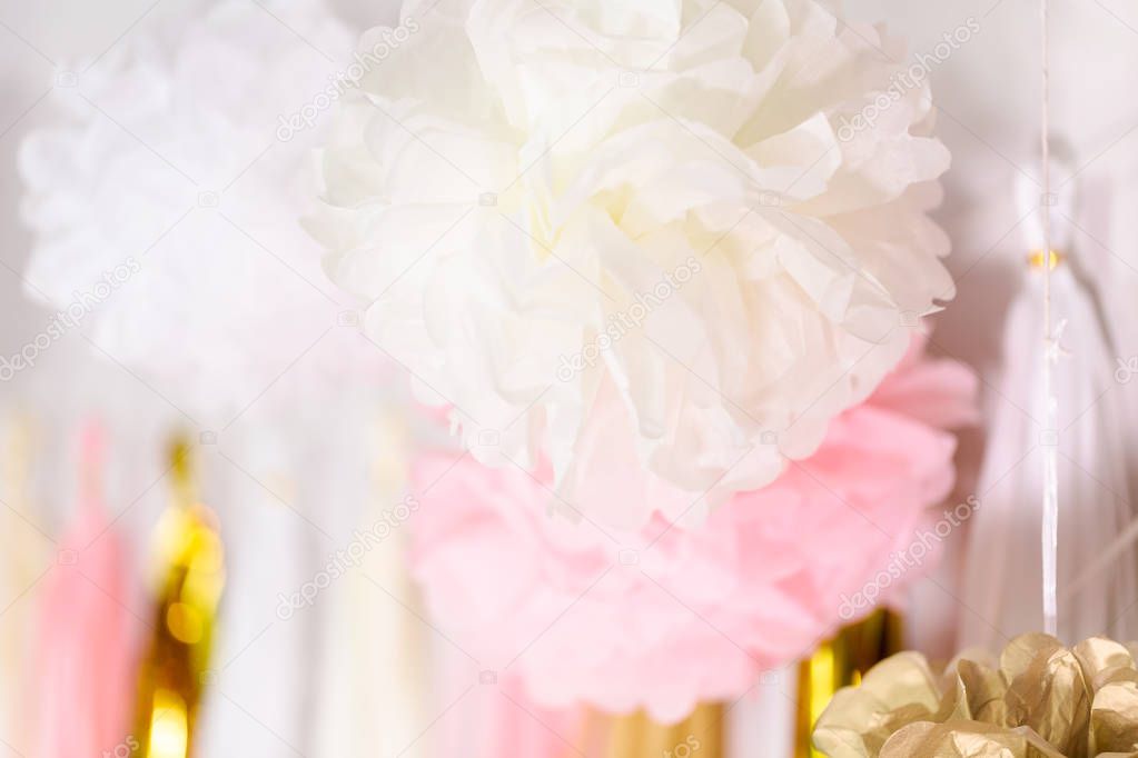 Pink and gold paper tassel garland on the wall at little girl birthday party.