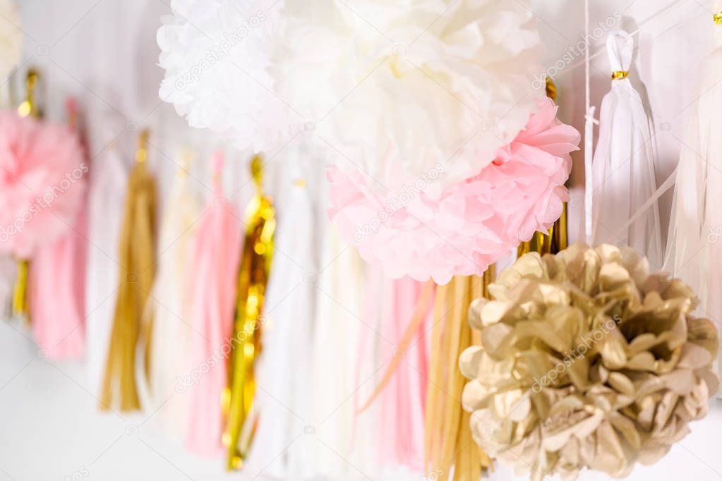 Pink and gold paper tassel garland on the wall at little girl birthday party.