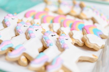 Tepsi küçük kız Doğum günü partisi hizmet üzerinde tek boynuzlu at şekerli kurabiye.