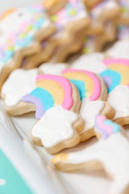 Tepsi küçük kız Doğum günü partisi hizmet üzerinde tek boynuzlu at şekerli kurabiye.