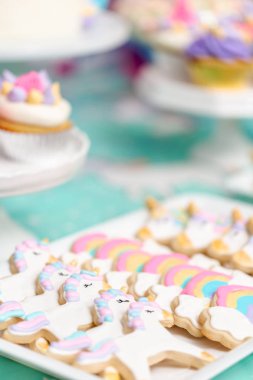 Tepsi küçük kız Doğum günü partisi hizmet üzerinde tek boynuzlu at şekerli kurabiye.