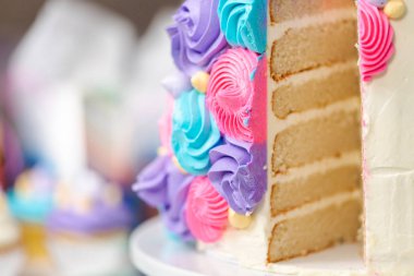 Çok katmanlı tek boynuzlu at kek kek stand küçük kız Doğum günü partisinde dilimlenmiş.