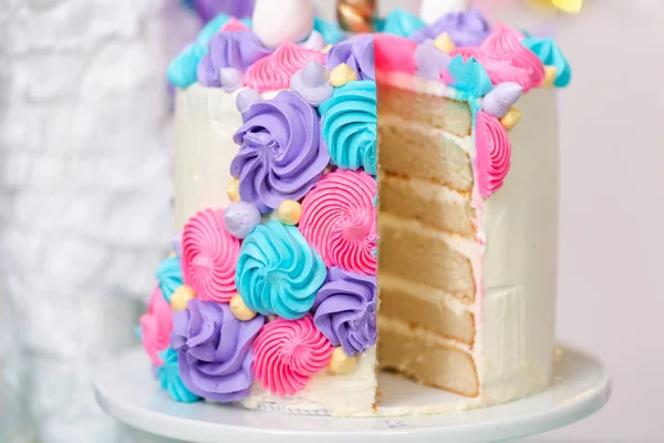 切片多层独角兽蛋糕站在小女孩的生日聚会上 — 图库照片