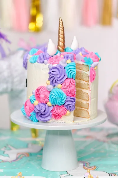 切片多层独角兽蛋糕站在小女孩的生日聚会上 — 图库照片
