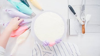 Adım adım. Pasta şefi boru tereyağı krema küçük kız Doğum günü partisi için tek boynuzlu at pasta üzerinde buzlanma.