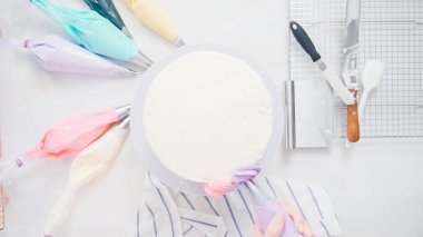Adım adım. Pasta şefi boru tereyağı krema küçük kız Doğum günü partisi için tek boynuzlu at pasta üzerinde buzlanma.