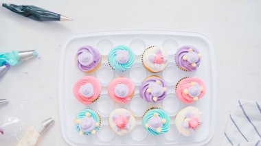 Adım adım. Pasta şefi boru tereyağı krema küçük kız Doğum günü partisi için tek boynuzlu at cupcakes sırlı.
