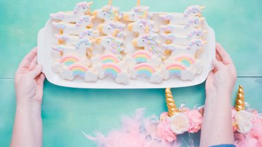 Tek boynuzlu at şekerli kurabiye mavi arka plan üzerine Kraliyet krema ile dekore edilmiş.