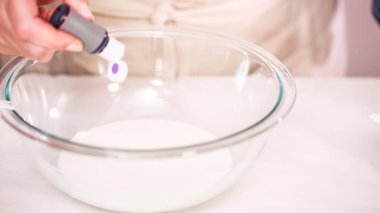 Gıda tek boynuzlu at şekerli kurabiye süslemek için Royal Icing içine boyama karıştırma.