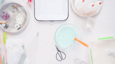 Gıda tek boynuzlu at şekerli kurabiye süslemek için Royal Icing içine boyama karıştırma.