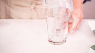 Gıda tek boynuzlu at şekerli kurabiye süslemek için Royal Icing içine boyama karıştırma.