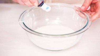 Gıda tek boynuzlu at şekerli kurabiye süslemek için Royal Icing içine boyama karıştırma.