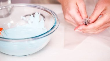 Gıda tek boynuzlu at şekerli kurabiye süslemek için Royal Icing içine boyama karıştırma.