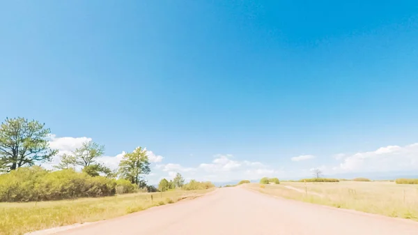 コロラド州の田園郊外住宅地におけるオープン スペースを介しての未舗装の道路上を運転 — ストック写真