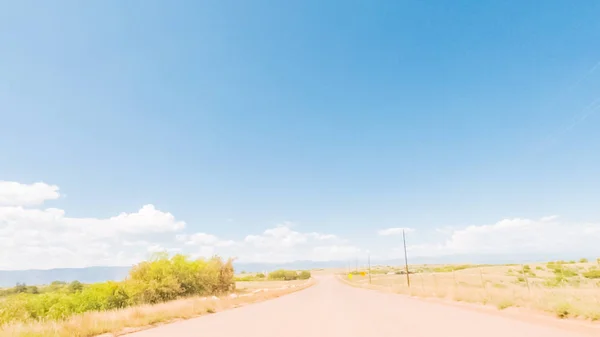 コロラド州の田園郊外住宅地におけるオープン スペースを介しての未舗装の道路上を運転 — ストック写真