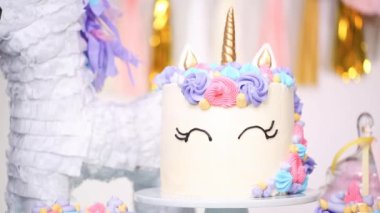 Küçük kızın Doğum günü partisinde parti masada buttercream pastayla tek boynuzlu at