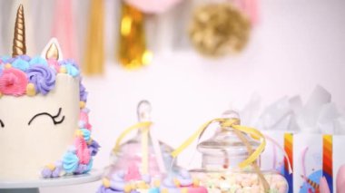 Küçük kızın Doğum günü partisinde parti masada buttercream pastayla tek boynuzlu at