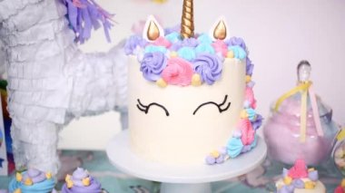 Küçük kızın Doğum günü partisinde parti masada buttercream pastayla tek boynuzlu at