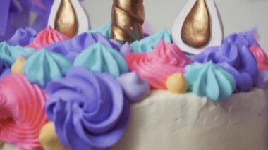 Ağır çekim. Tek boynuzlu at pasta küçük kız Doğum günü partisinde yakın çekim.