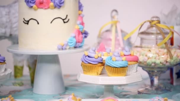 ユニコーン ケーキ カップケーキ シュガー クッキーと小さな女の子の誕生日パーティー テーブル — ストック動画