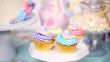 Küçük kızın Doğum günü partisi tablo tek boynuzlu at kek, top kek ve şekerli kurabiye ile yakın çekim.