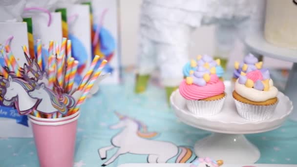ユニコーン ケーキ カップケーキ シュガー クッキーと小さな女の子の誕生日パーティー テーブルのクローズ アップ — ストック動画