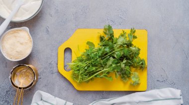 Ahşap kesme tahtası üzerinde kesme kişniş.