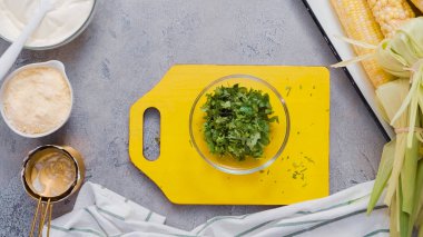 Ahşap kesme tahtası üzerinde kesme kişniş.