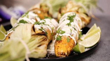 Elote plaka hizmet üzerinde taze kişniş ile süslenmiş Meksika Mısır
