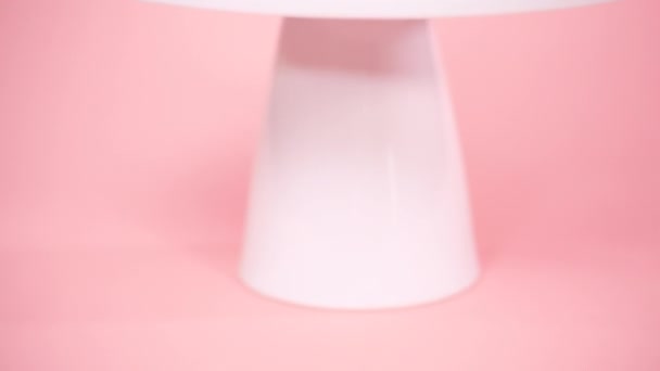 在粉红色背景下用多色奶油糖衣装饰独角兽蛋糕的特写 — 图库视频影像