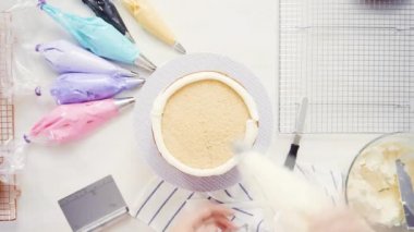 Adım adım. Üstten görünüm. Pasta Şef yığın pasta katmanları arasında tek boynuzlu at pasta oluşturmak için buzlanma buttercream ile