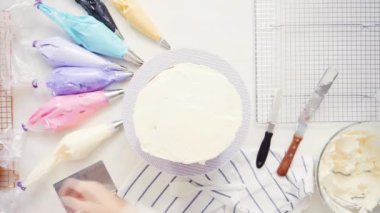 Adım adım. Üstten görünüm. Pasta Şef yığın pasta katmanları arasında tek boynuzlu at pasta oluşturmak için buzlanma buttercream ile