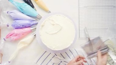 Zaman atlamalı. Adım adım. Üstten görünüm. Pasta Şef yığın pasta katmanları arasında tek boynuzlu at pasta oluşturmak için buzlanma buttercream ile